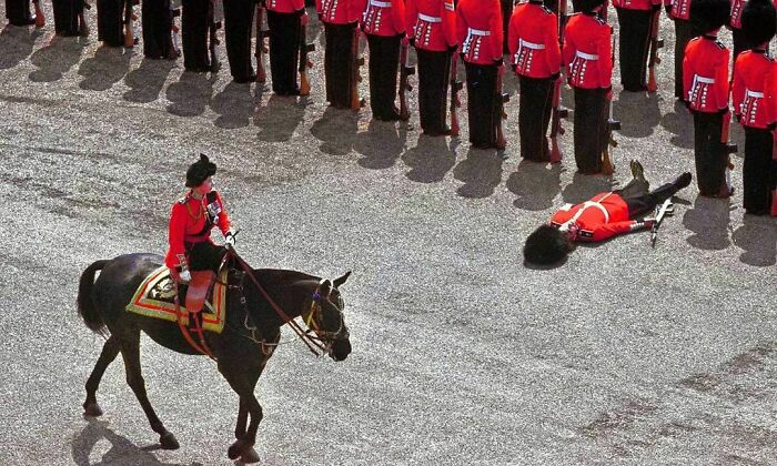 A Guard Passes Out As Queen Elizabeth II Rides By. 1970