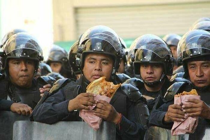 Policía mexicana haciendo un descanso para comer en mitad de las protestas. 2016