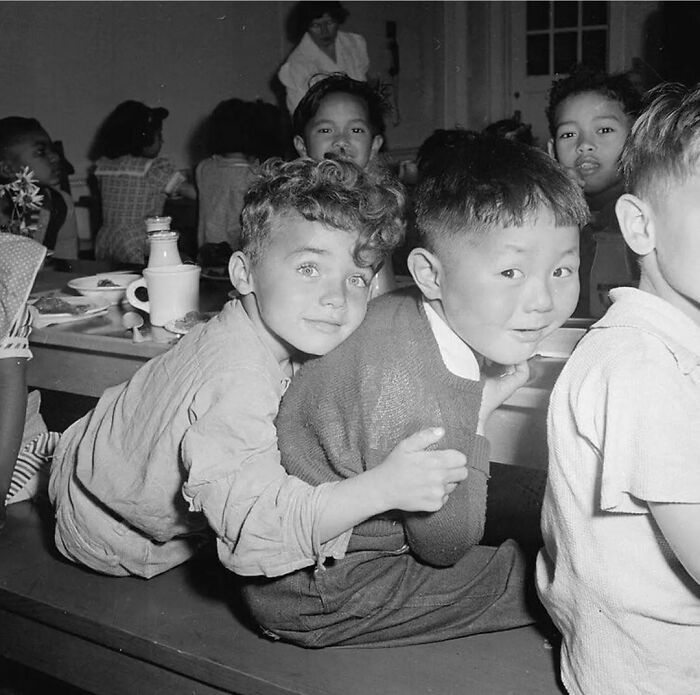 A Little Boy Hugging His Best Friend During Lunchtime At Raphael Weill Public School In San Francisco, California In 1942
