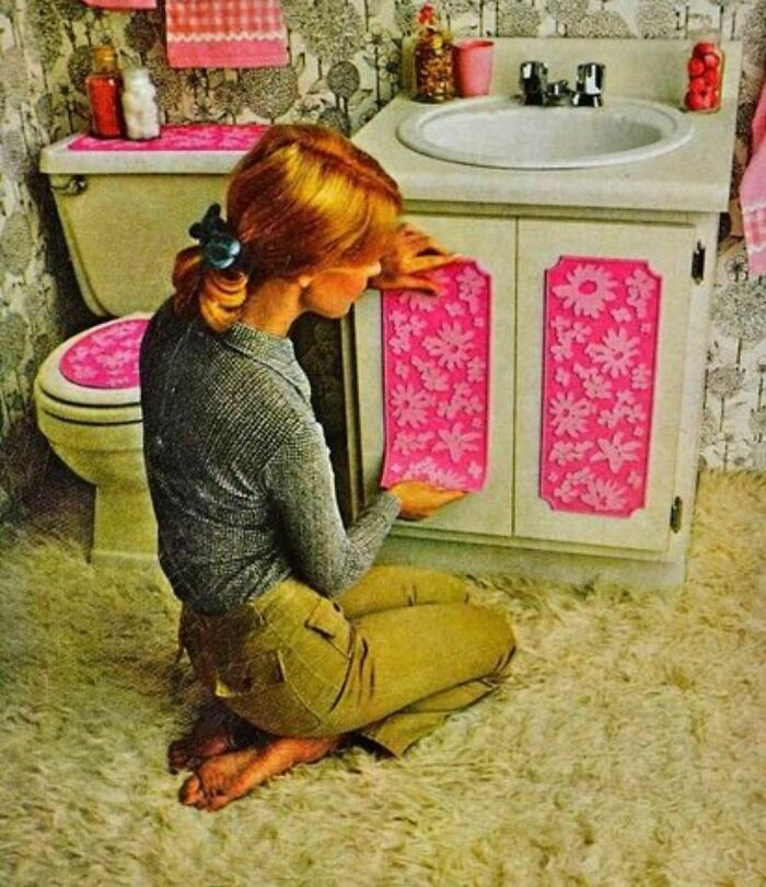 A Woman Applying Pink Floral Fabric To Her Bathroom Cabinets And Fixtures, 1970's