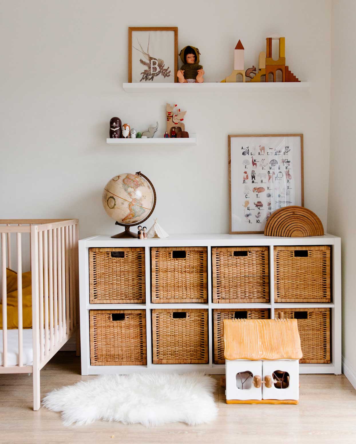 Children's bedroom with wooden furniture, toys, and a globe placed on shelves in the room Children's bedroom with wooden furniture, toys, and a globe placed on shelves in the room
