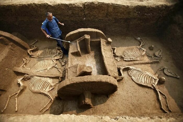 To Protect It From Drying Out, A Worker Sprays Water Onto A Millennia-Old Chariot Recently Unearthed In The City Of Luoyang In Central China