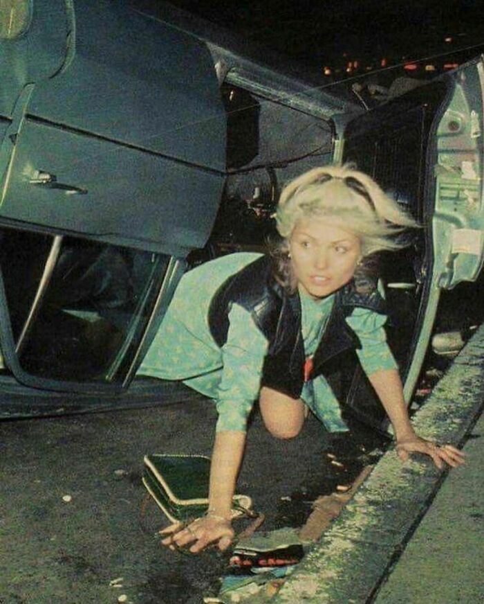 Debbie Harry Of Blondie In A Wrecked Car On 6th Avenue And 50th Street In New York City. September 1976. Photo By Bob Gruen
