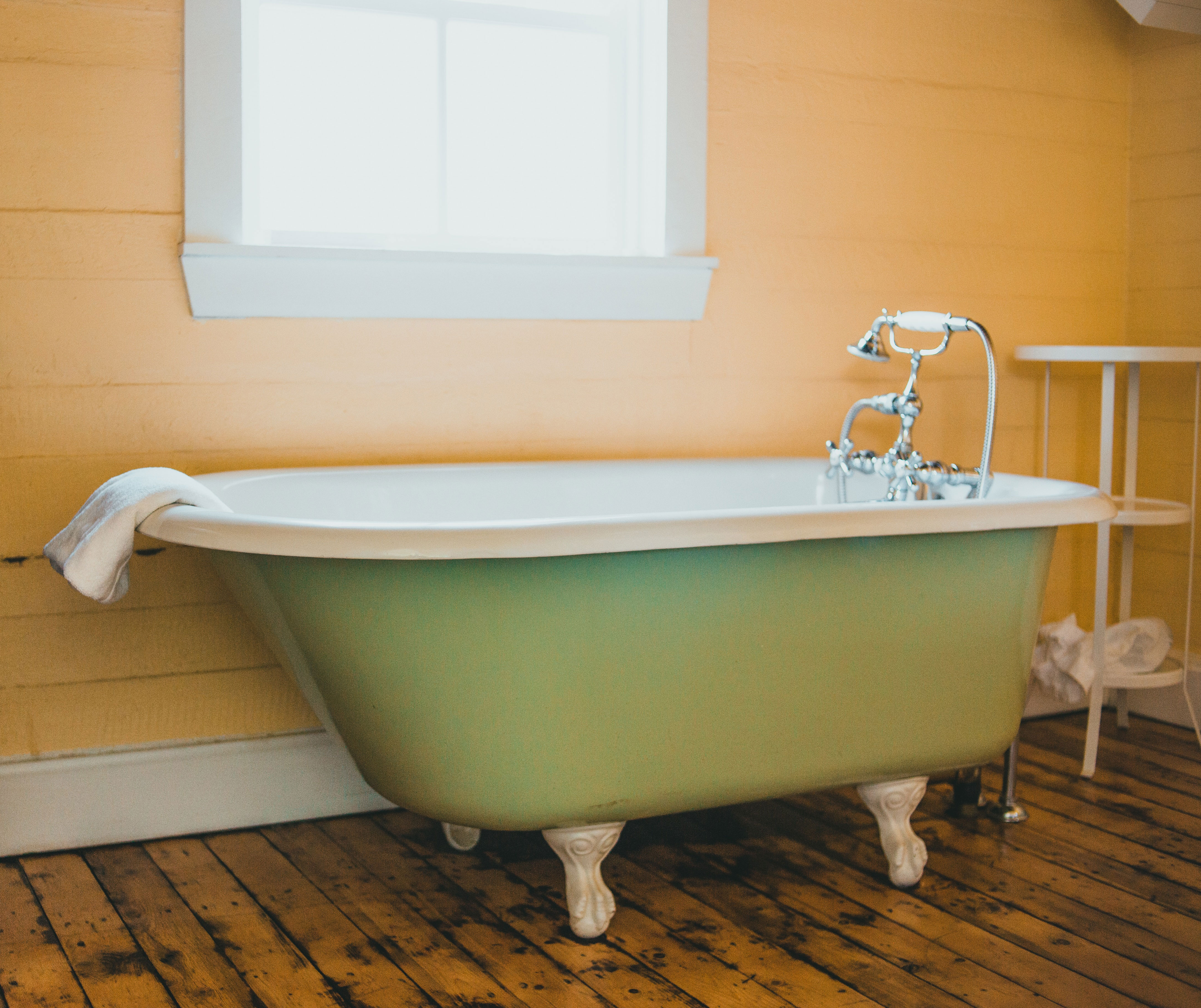 Pastel green clawfoot tub near the wall.