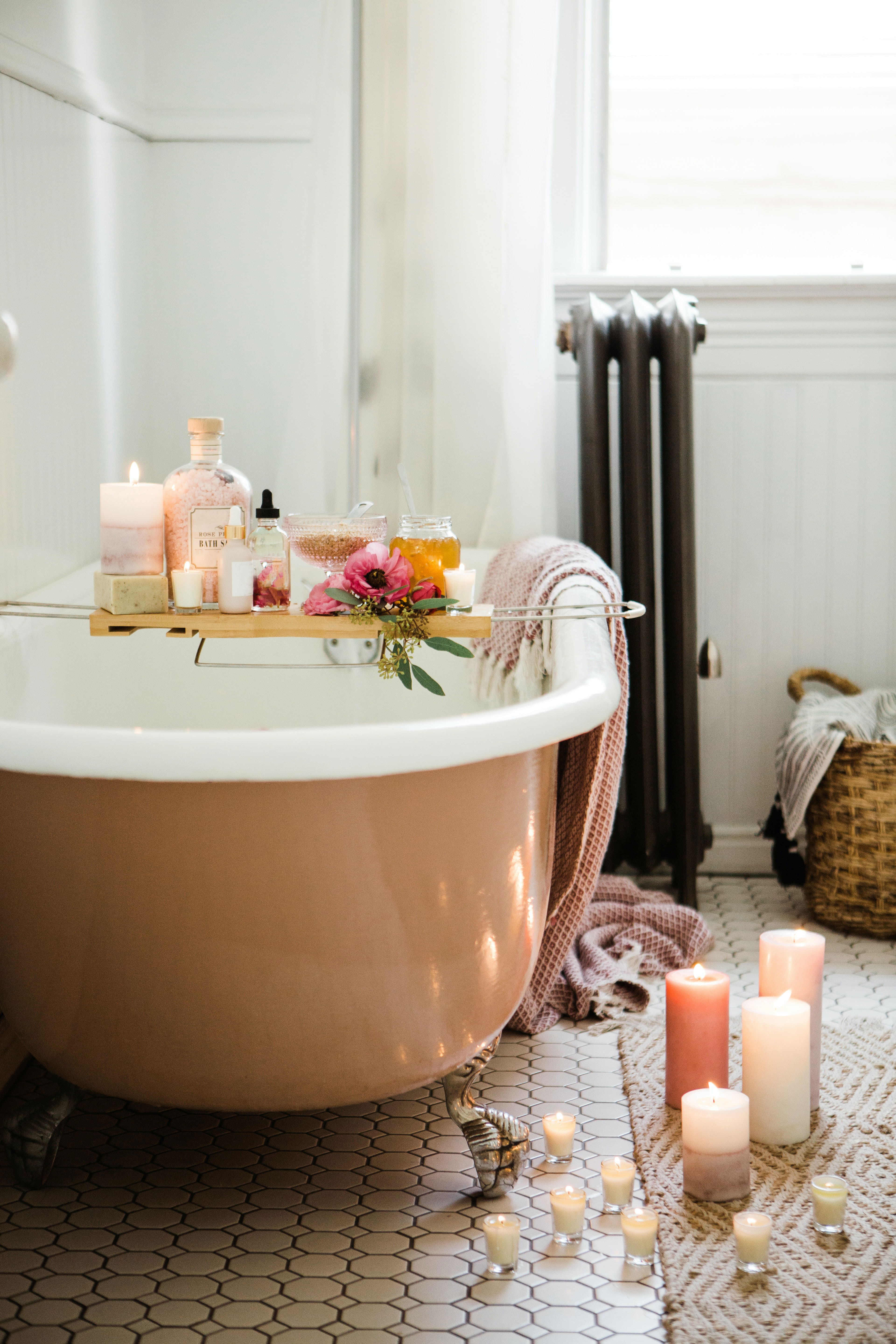 Clawfoot tub decorated with flowers and candles.