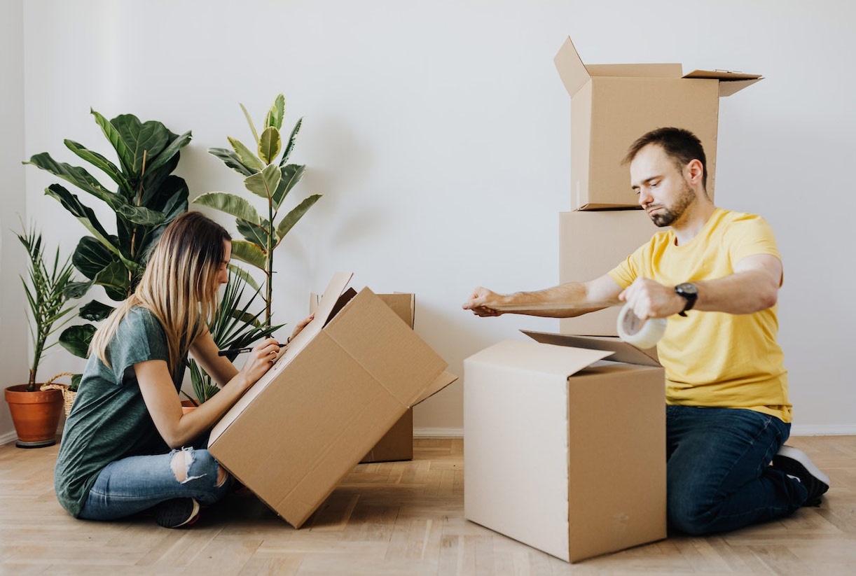 A couple is sealing carton boxes A couple is sealing carton boxes