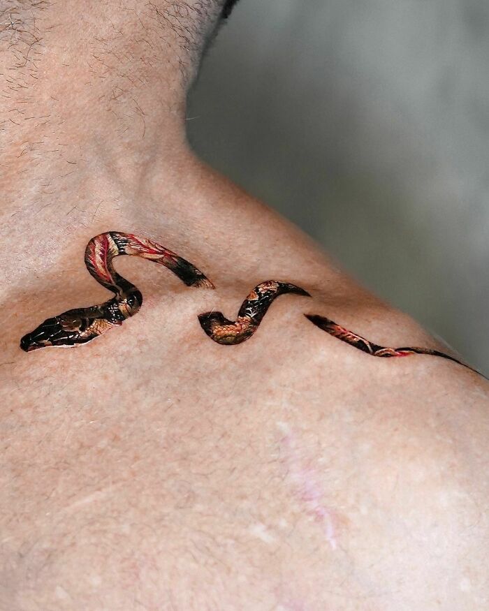 Flower patterned snake tattoo