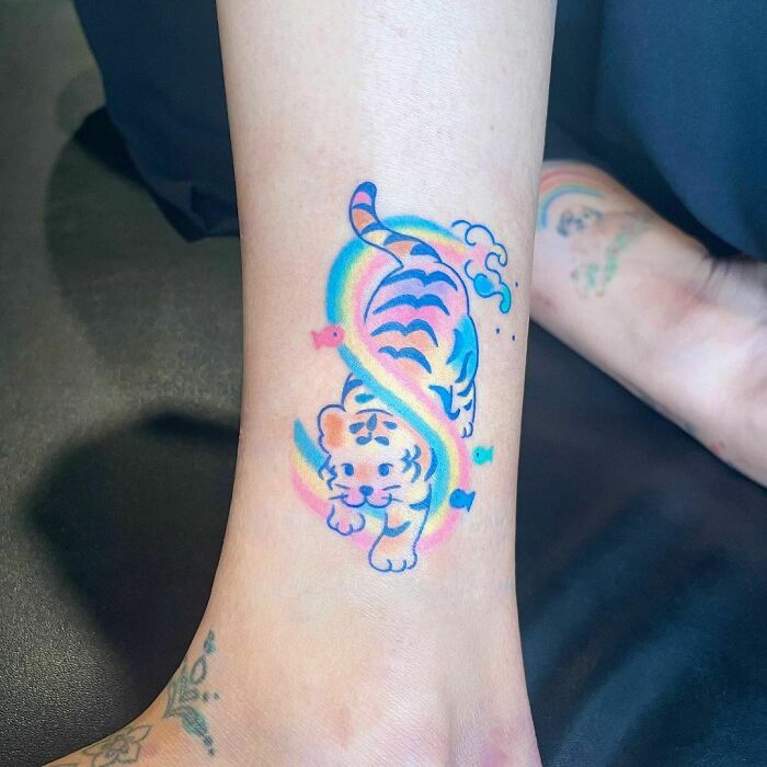 Watercolor tiger playing with rainbow ankle tattoo