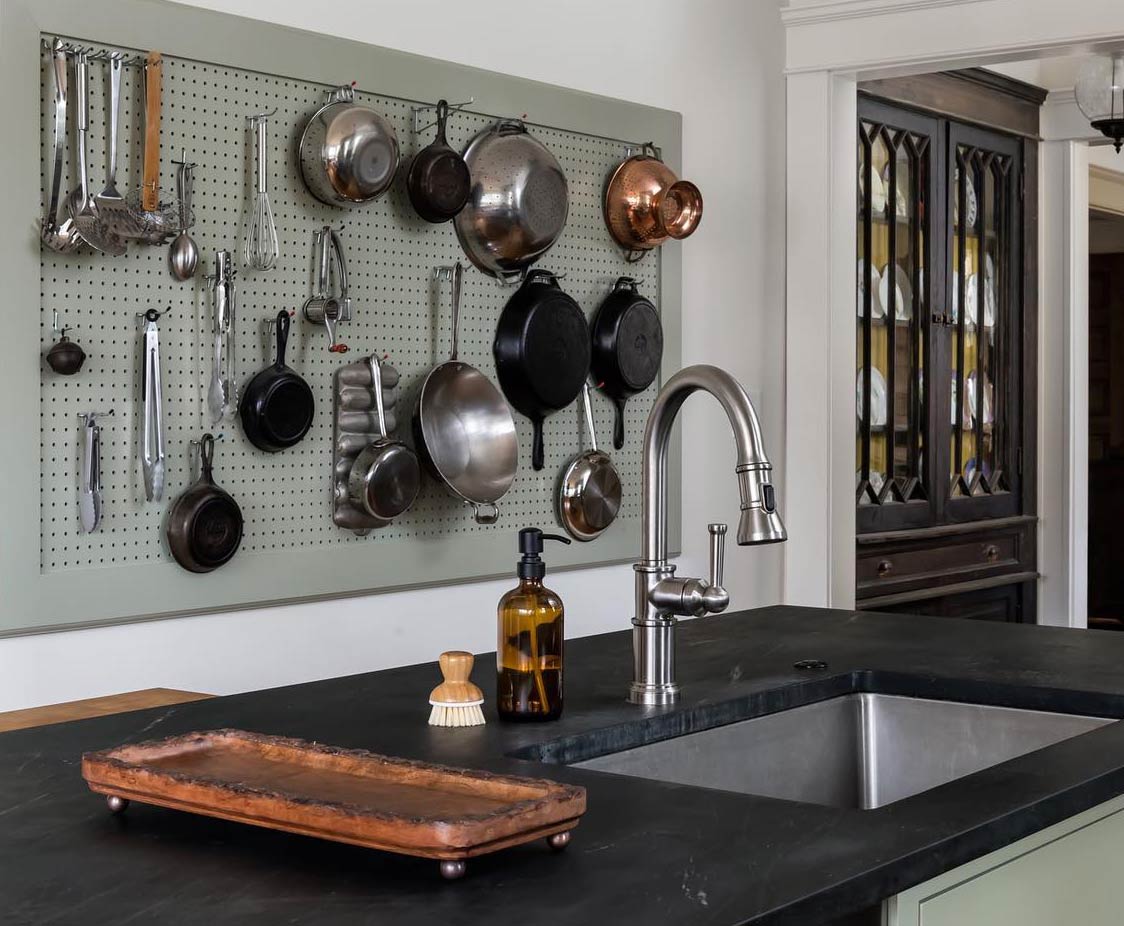 Gray kitchen pegboard with pots and pans hanging