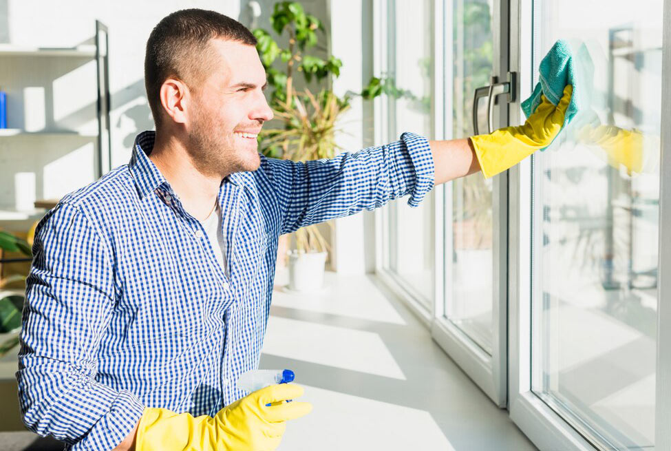 A man cleaning a window in sunlight A man cleaning a window in sunlight