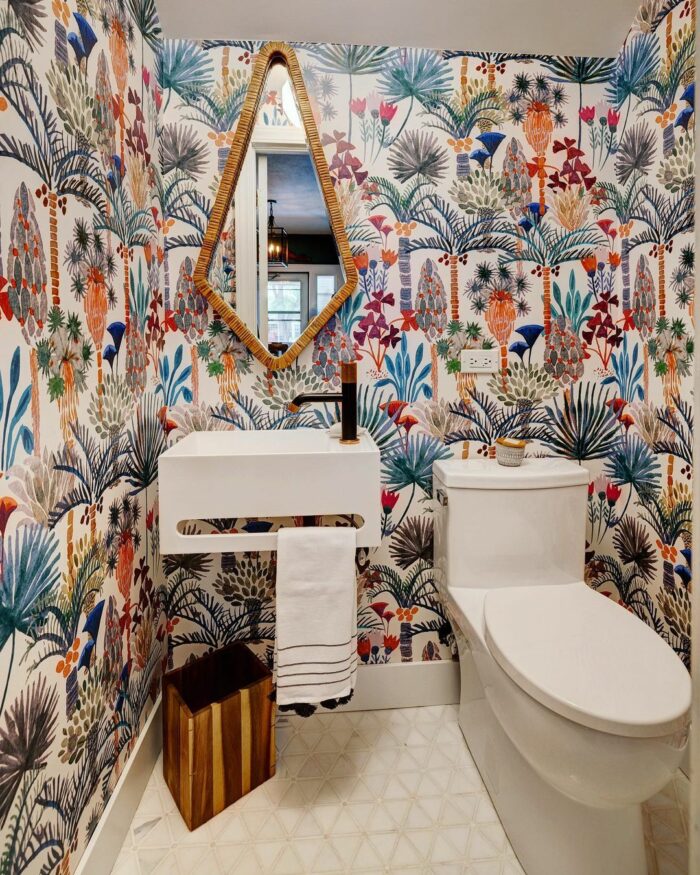 Bathroom with colorful flower wallpaper and sink with toilet