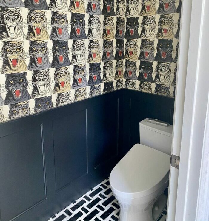 Bathroom featuring tiger pattern wallpaper and stylish black wainscoting, showcasing trendy bathroom wallpaper ideas. Bathroom featuring tiger pattern wallpaper and stylish black wainscoting, showcasing trendy bathroom wallpaper ideas.