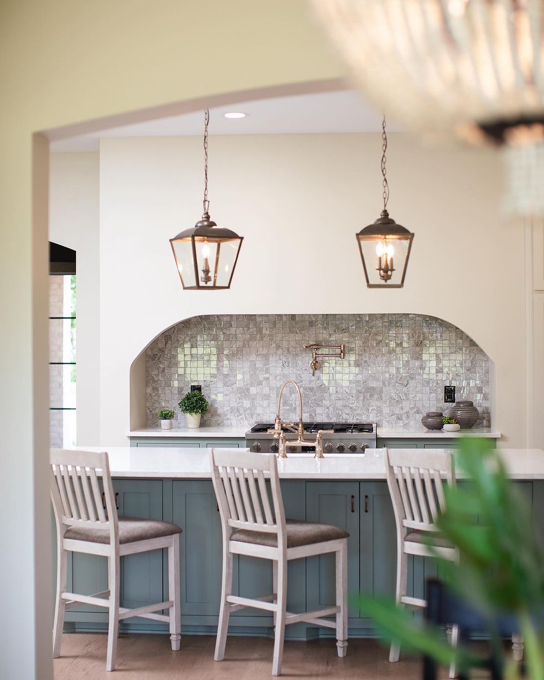 Kitchen with gray blue marble table and chairs and rustic lanterns
