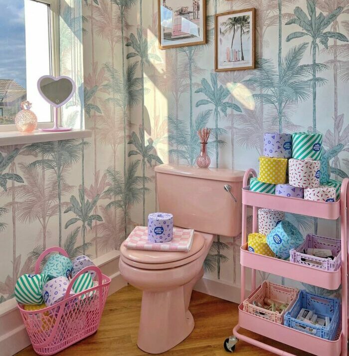 Bathroom with pastel tropical wallpaper and pink toilet