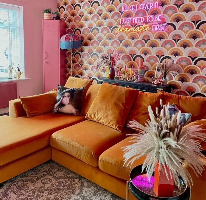 a maximalist living room with a brown sofa and semicircle-patterned wallpaper