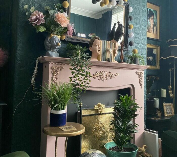 a maximalist living room with small sculptures and plants kept on a fireplace