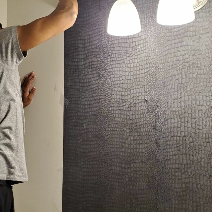 Black crocodile embossed wallpaper in bathroom under pendant lights showcasing trendy bathroom wallpaper ideas. Black crocodile embossed wallpaper in bathroom under pendant lights showcasing trendy bathroom wallpaper ideas.