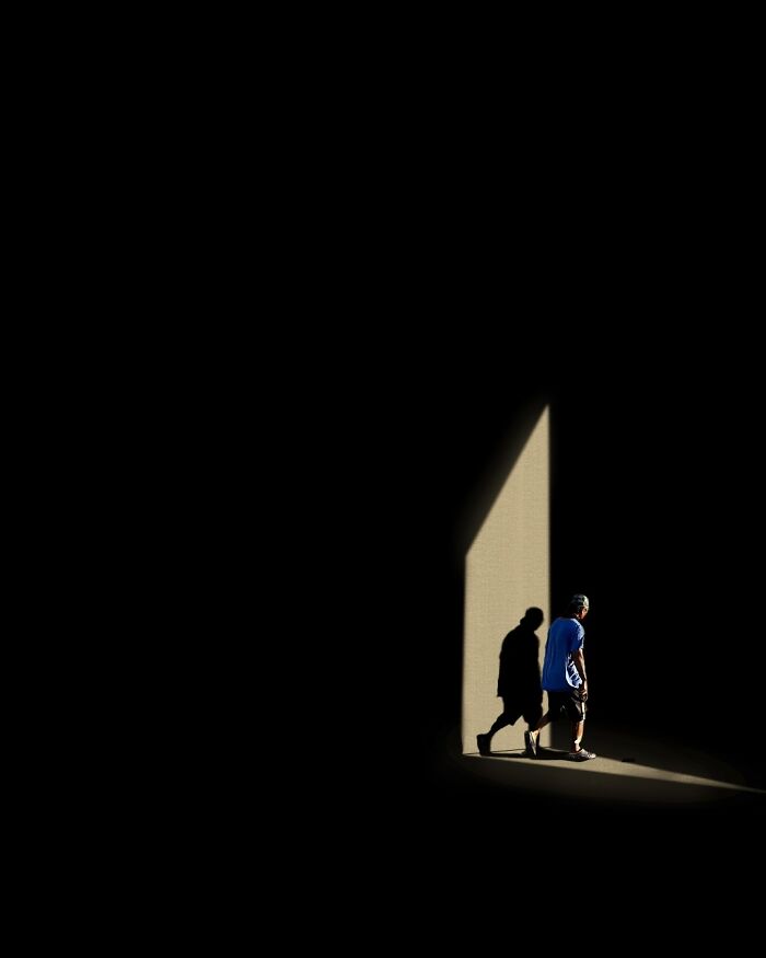 A photograph of a person and their shadow