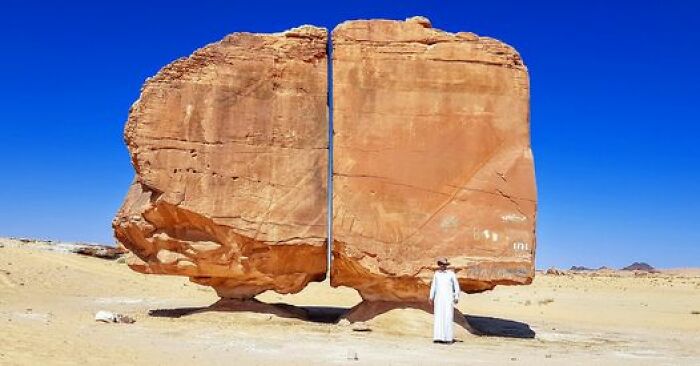 Located 50 Km South Of The Tayma Oasis In Saudi Arabia, The Al Naslaa Rock Is A Fascinating Landform. What Makes It Truly Unique Is Its Division Into Two Parts, Each Delicately Balanced On Small Pedestals. The Rock's Distinctive Shape Is Thought To Have Resulted From A Combination Of Wind Erosion And Chemical Weathering, Likely Facilitated By The Moist Conditions Beneath Its Protective Underside. While There Appears To Be A Division Caused By A Possible Joint, The Certainty Of This Explanation Remains Uncertain