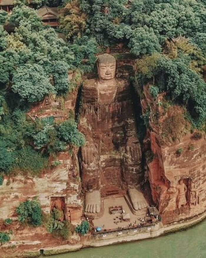 Standing At A Remarkable Height Of 71 Meters (233 Feet), The Leshan Giant Buddha Is A Monumental Stone Sculpture That Was Constructed Between The Years 713 And 803, A Period Encompassing The Tang Dynasty. During Its Creation, An Ingenious Drainage System Was Ingeniously Integrated Into The Statue's Design, A System That Endures To This Day. This Innovative Approach Entails Intricately Carved Drainage Pipes Dispersed Throughout Various Sections Of The Statue's Form, Facilitating The Efficient Runoff Of Rainwater And Thereby Mitigating The Effects Of Weathering. In The Course Of Crafting The Giant Buddha, An Immense Thirteen-Story Wooden Edifice Was Painstakingly Erected To Provide Shelter From Both Rain And Sunlight. Regrettably, This Shelter Met Its Demise And Fell Victim To Plunder And Destruction By The Mongols During The Conflicts That Marked The Close Of The Yuan Dynasty. Following This Pivotal Juncture, The Colossal Stone Sculpture Stood Exposed, Subject To The Elements' Influence