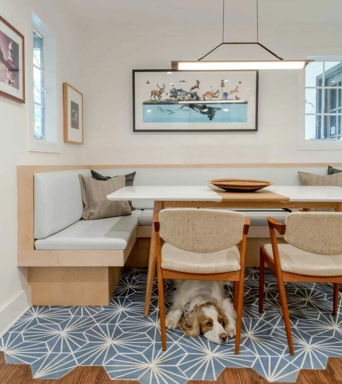 Wooden banquette with white table chairs and dog