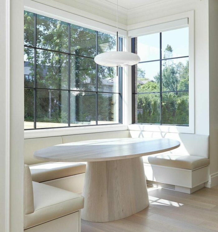 White banquette near white window and white table