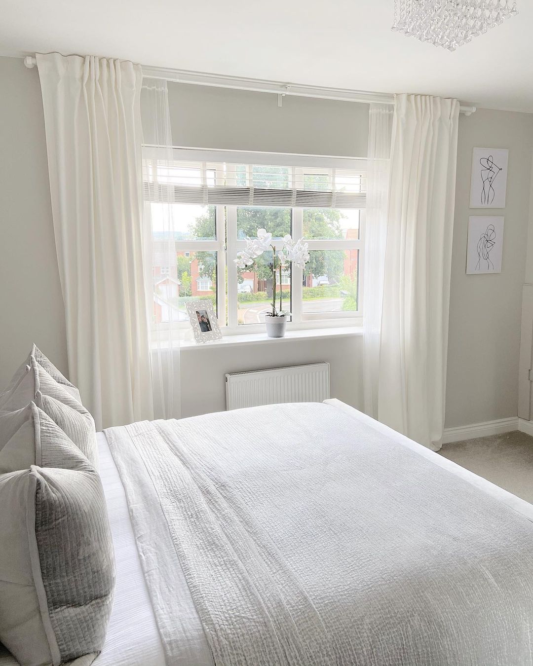 big bed near the window in white bedroom