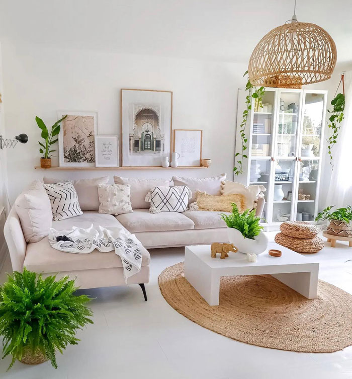 Living room with pillows on the beige couch and paintings on the wall