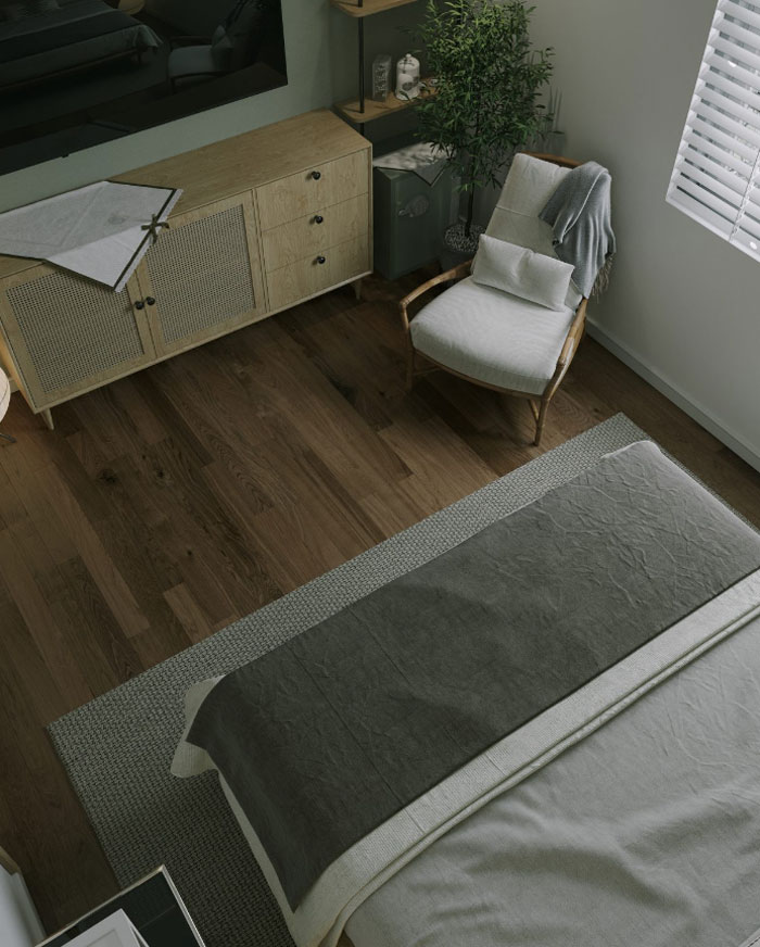A bed with dark grey shits, wooden low cabinet