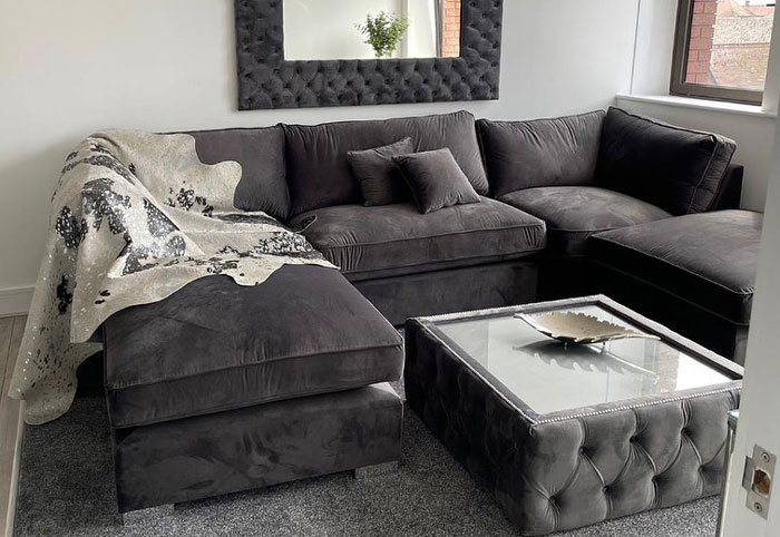 Dark gray U-shaped cheap couch with plush cushions and matching ottoman in a modern living room setting. Dark gray U-shaped cheap couch with plush cushions and matching ottoman in a modern living room setting.