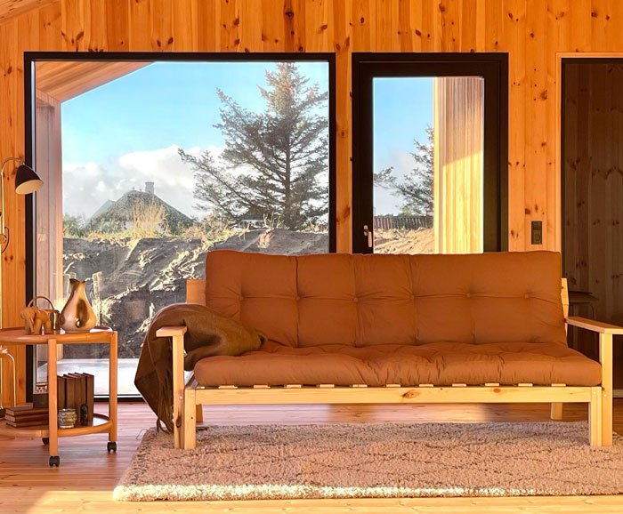 Brown futon sofa with wooden frame in a cozy room, showcasing one of the best budget-friendly cheap couches. Brown futon sofa with wooden frame in a cozy room, showcasing one of the best budget-friendly cheap couches.