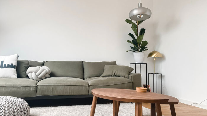 Off green simple three-seater couch in a modern living room, showcasing one of the best budget-friendly cheap couches options. Off green simple three-seater couch in a modern living room, showcasing one of the best budget-friendly cheap couches options.
