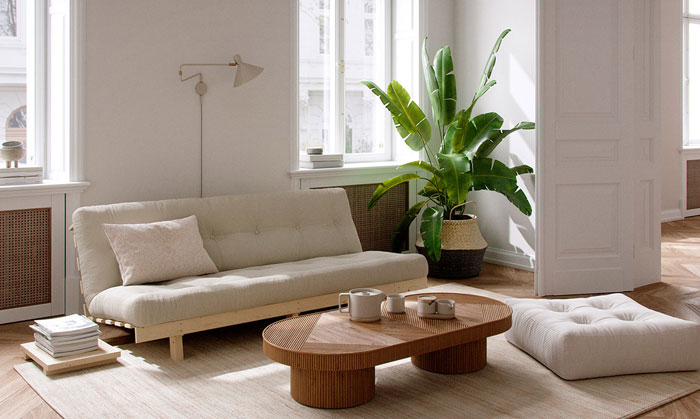 white futon sofa with an extra pillow in a beige living room