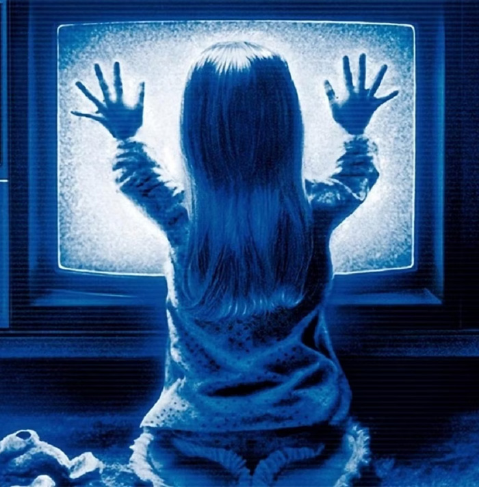 Child with long hair facing static TV screen, hands pressed against it, creating a creepy and scary facts atmosphere.