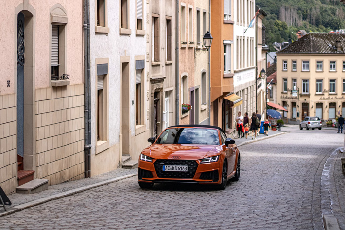 Orange car on a cobblestone street in Vianden, Luxembourg