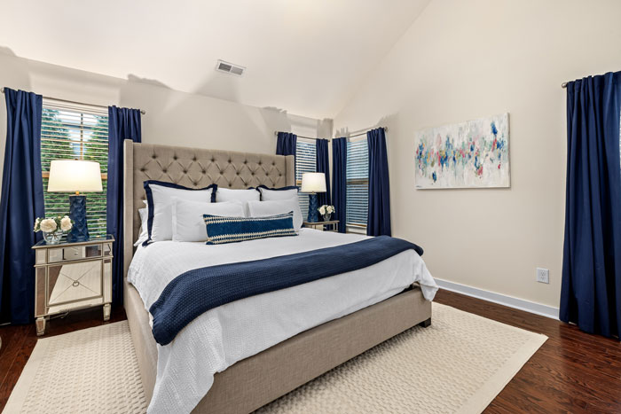 big bed with white and blue color linen and blue curtains on the windows big bed with white and blue color linen and blue curtains on the windows
