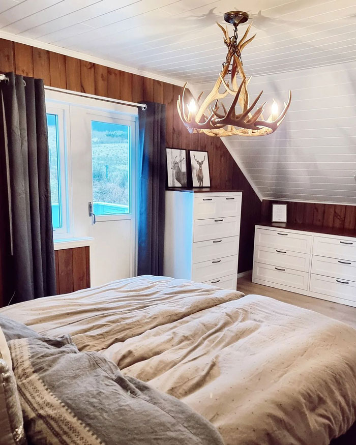 chandelier with antler over the bed and dark gray curtains on the balcony window chandelier with antler over the bed and dark gray curtains on the balcony window