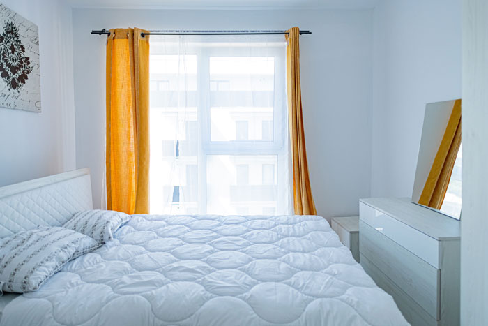 yellow curtains on the windows in a white bedroom
