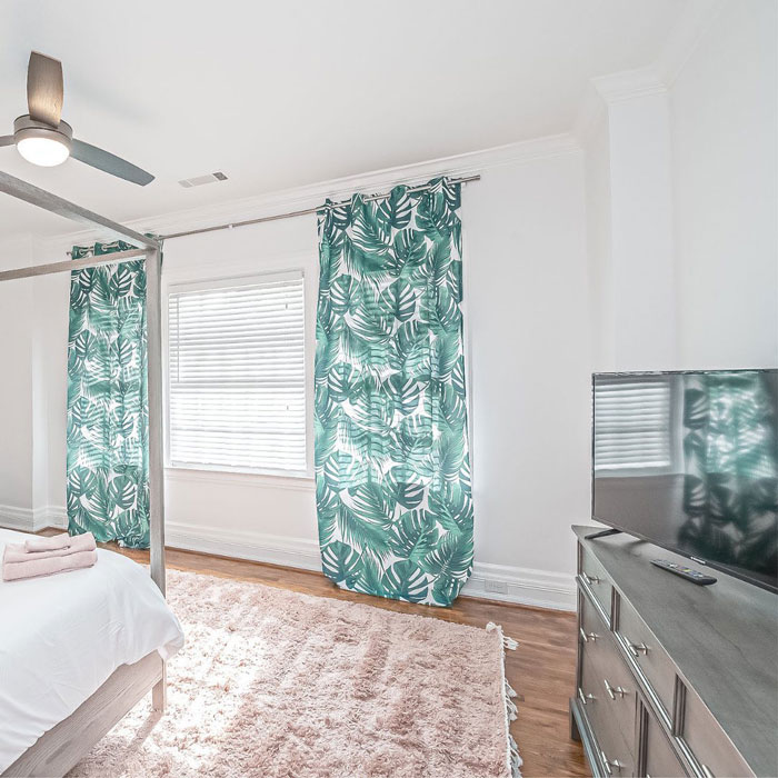 tropical patterned curtains on the window in a white bedroom