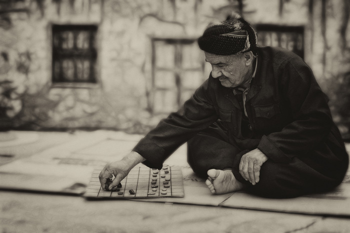 old man playing a table top game