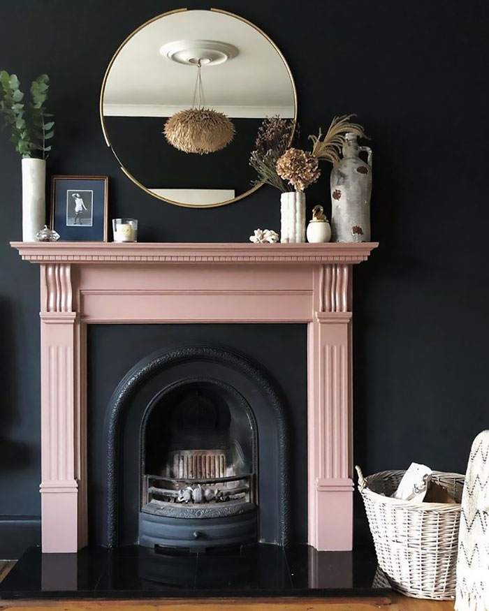 Dark living room fireplace with a contrasting pink mantel