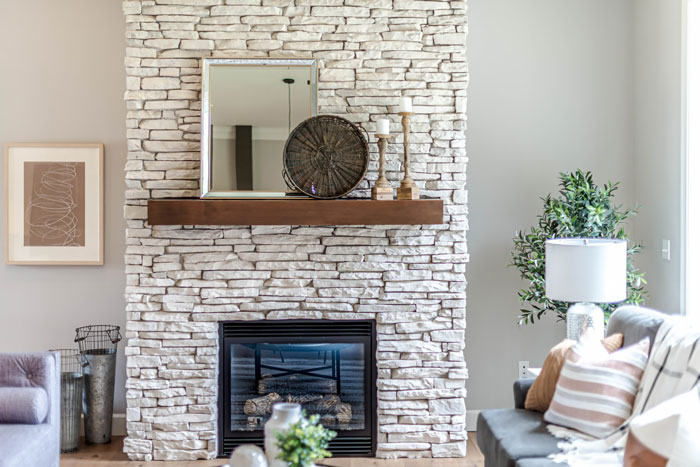Bright living room with white brick fireplace and a floating wooden mantle