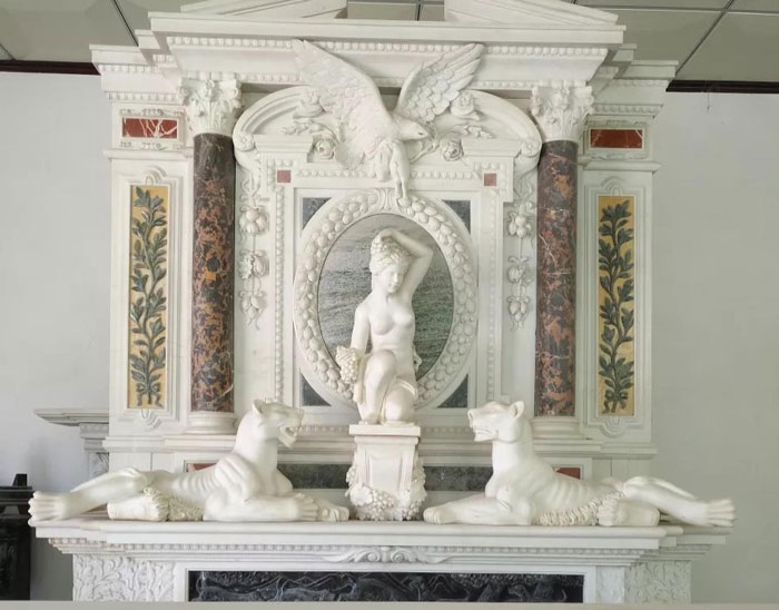 white antique marble fireplace mantel with attached sculptures of tigers, eagles and Aphrodite 