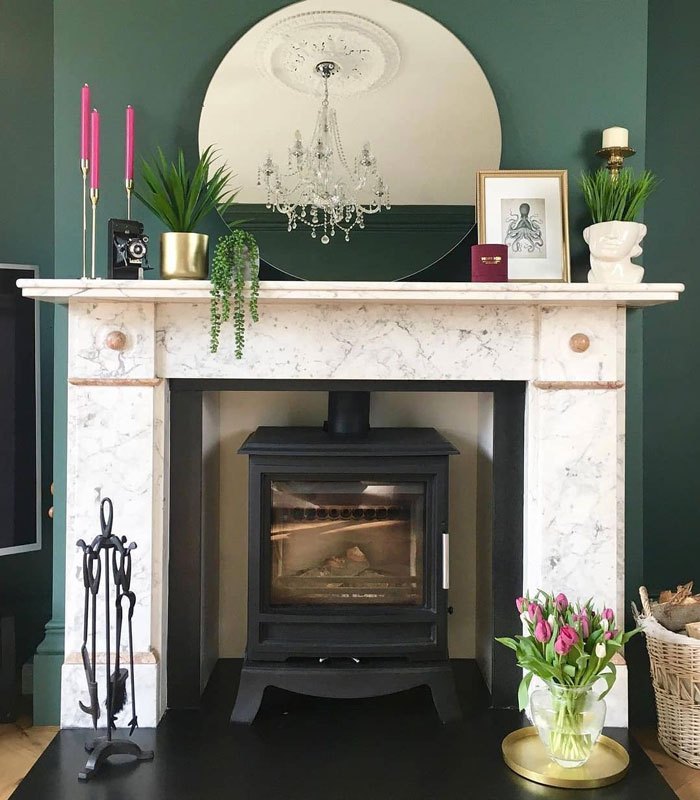 white marble fireplace mantle with pink candles and greenery
