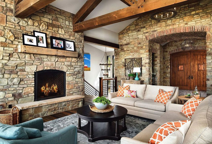 stone brick living room with family pictures on the fireplace mantle