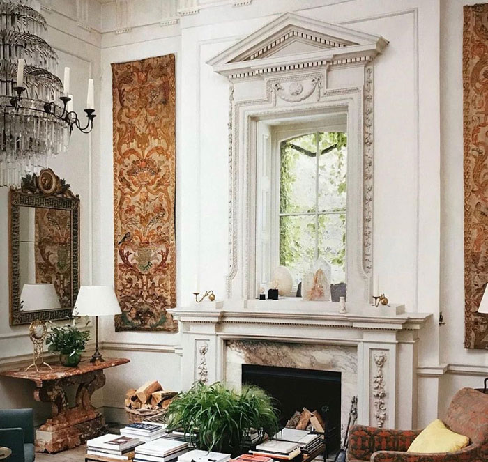 Stone fireplace mantel with decorative moldings and a window above in an elegant living room setting Stone fireplace mantel with decorative moldings and a window above in an elegant living room setting