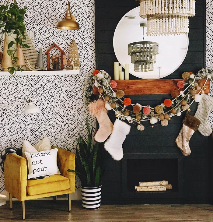 Black fireplace with a wooden mantle decorated in boho style