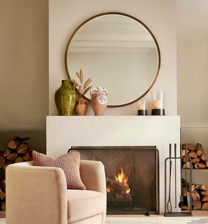Natural color living room with simple fireplace mantel decorated with design vases and candles for cozy hearth. Natural color living room with simple fireplace mantel decorated with design vases and candles for cozy hearth.