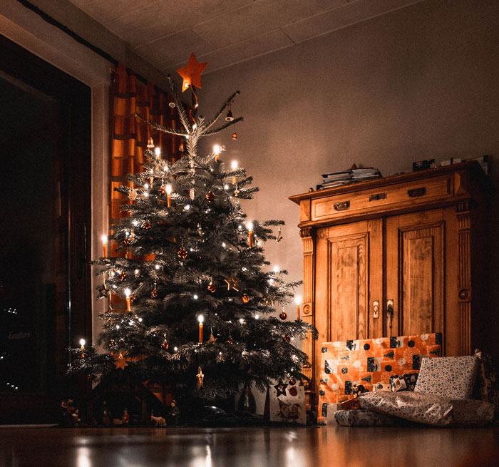 Decorated Christmas tree with gifts on its side 