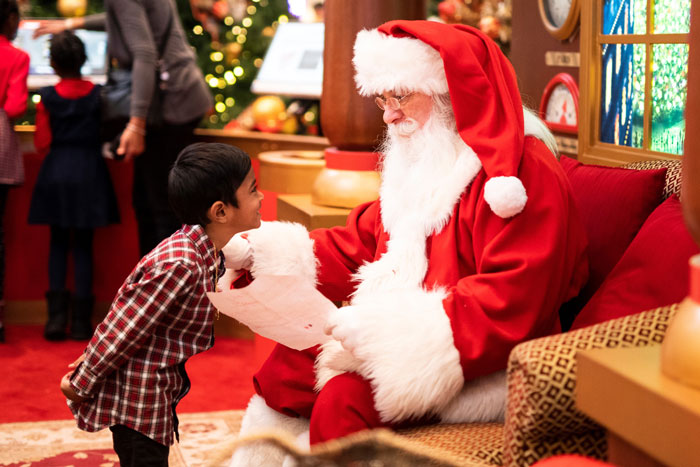 Boy standing in front of Santa Claus 